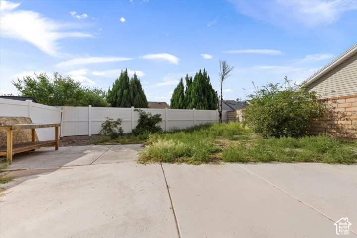 Concrete patio area with a white privacy fence