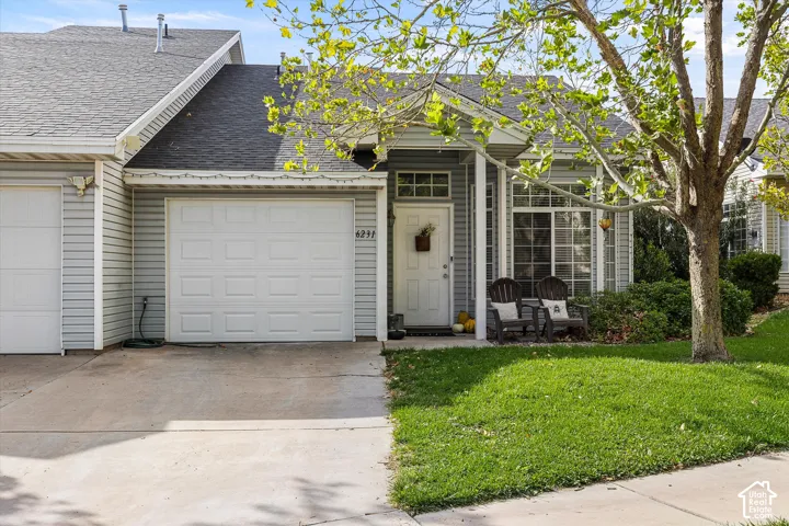 Siding exterior with a single-car garage, concrete driveway, and covered entry