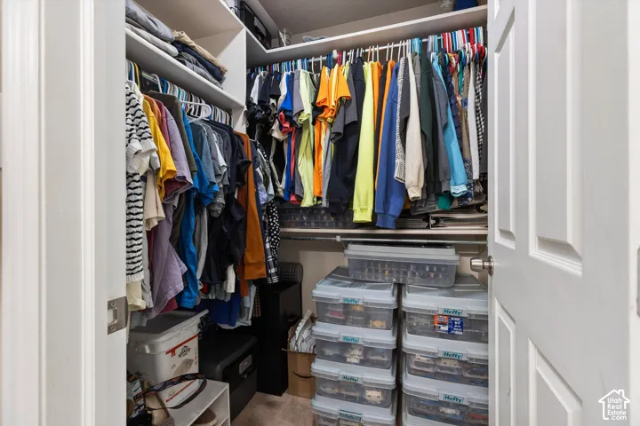 Reach-in closet featuring multiple shelves and hanging rods for organized storage