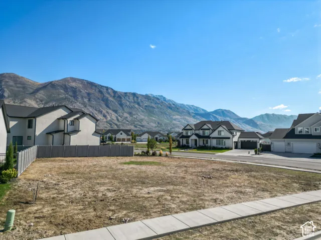 Expansive lot featuring a concrete sidewalk and mountain backdrop