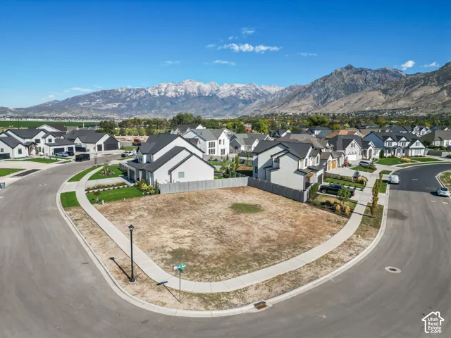 Corner lot offering a clear building site, surrounded by new construction homes, with a paved street and sidewalk infrastructure