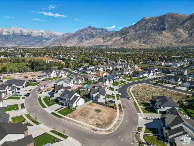 Residential development with mountain backdrop, paved streets, and landscaped lots