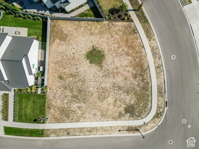 Expansive lot with established street infrastructure, including a paved road and concrete sidewalks