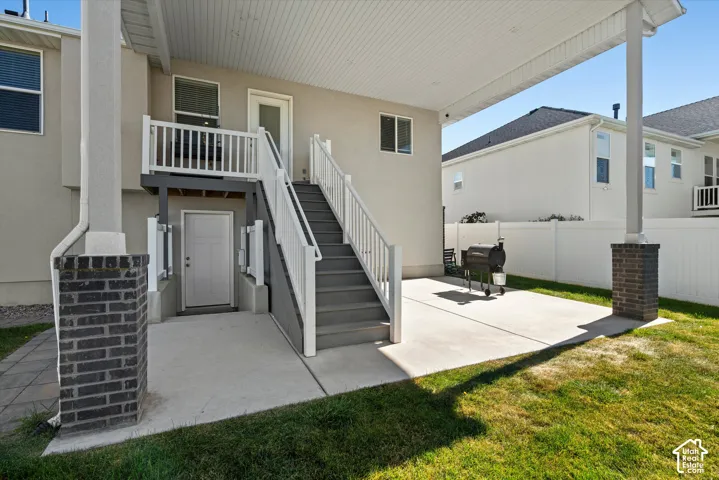 Covered patio with concrete flooring, supported by brick-clad columns
