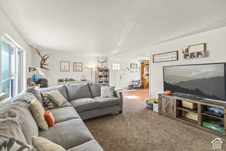 Spacious living area featuring light-colored walls, recessed lighting, and a large window