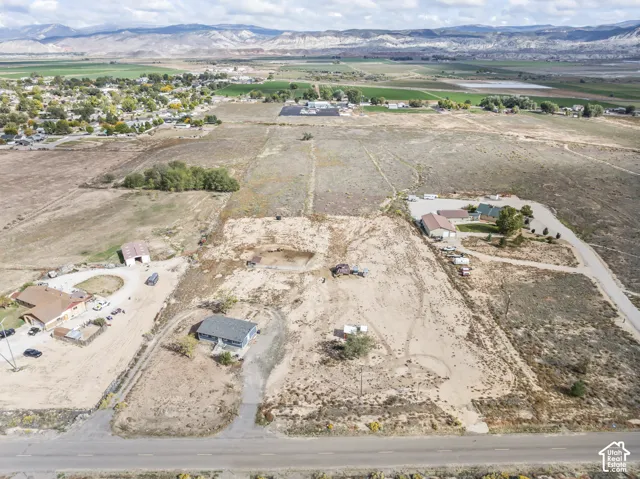Expansive land parcel featuring multiple buildings, including a residential structure with a dark gray roof
