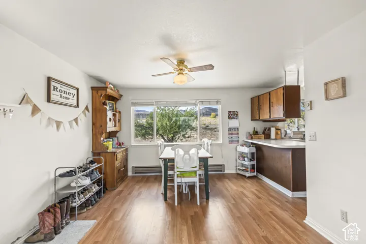 Wood-finish flooring throughout, bright white walls, and a ceiling fan with integrated lighting