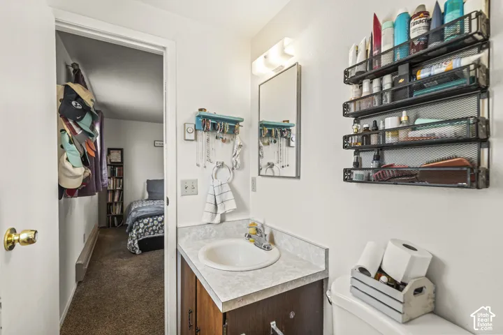 Bathroom vanity with an oval sink, laminate countertop, and wood-finish cabinetry