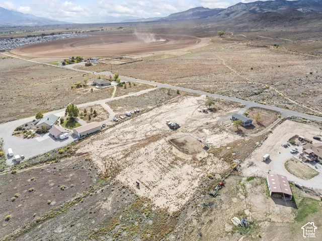 Expansive property with a private road, multiple outbuildings, and a surrounding natural landscape