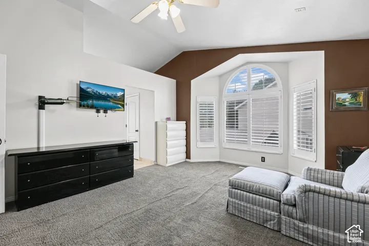 Vaulted ceilings with a ceiling fan, a bay window with an arched transom, and built-in window shutters