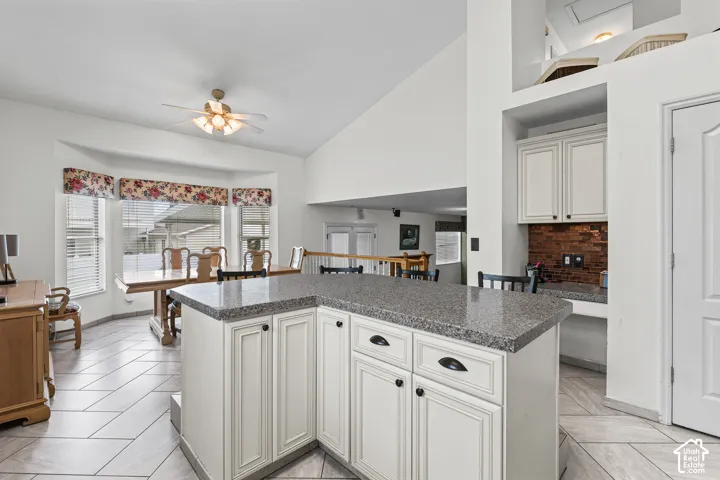 Kitchen island with light cabinetry and a stone-finish countertop