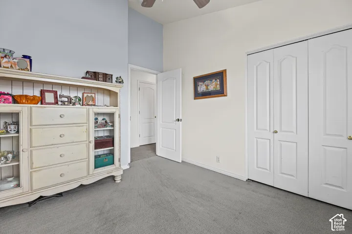 Wall-to-wall carpeting with multiple bi-fold closet doors and a ceiling fan