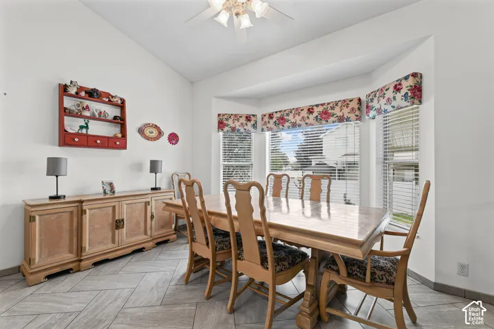 Vaulted ceilings, bay windows, ceiling fan, and tile flooring