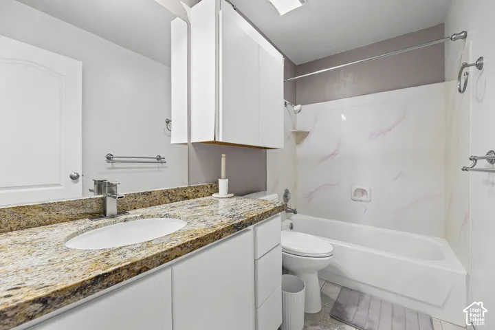 White vanity with an integrated sink and a stone-finish countertop