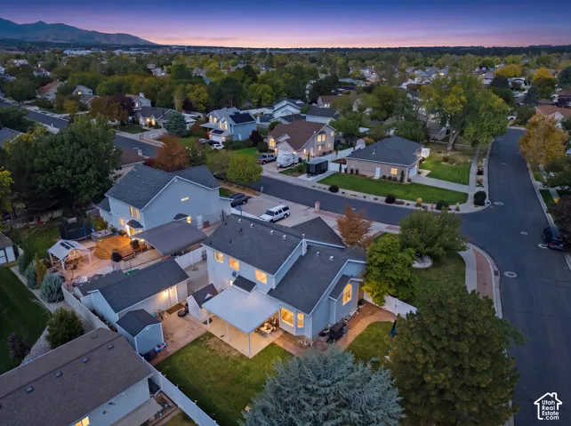 Expansive backyard featuring a multi-level deck, covered patio, manicured lawn, and mature trees