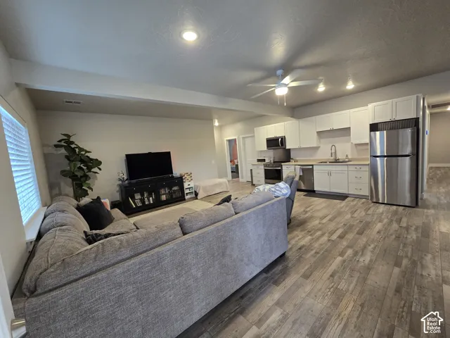 Open-concept living space featuring wood-finish flooring, recessed lighting, and a ceiling fan