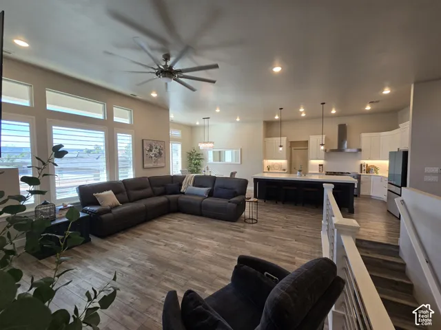 Spacious living area featuring wood-finish flooring, recessed lighting, and a large ceiling fan