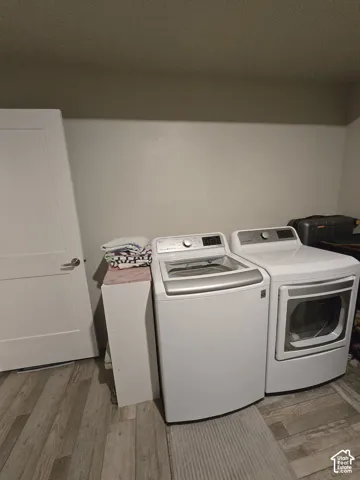 Laundry area with wood-finish flooring