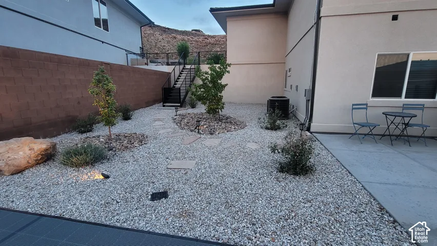 Xeriscape landscaping with gravel ground cover, mature plantings, and integrated stone accents