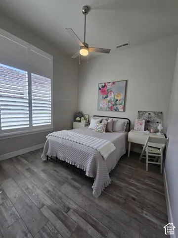 Wood-finish flooring, plantation shutters, and a ceiling fan with integrated lighting