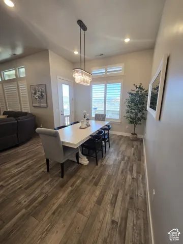 Wood-finish flooring, recessed lighting, and a crystal chandelier