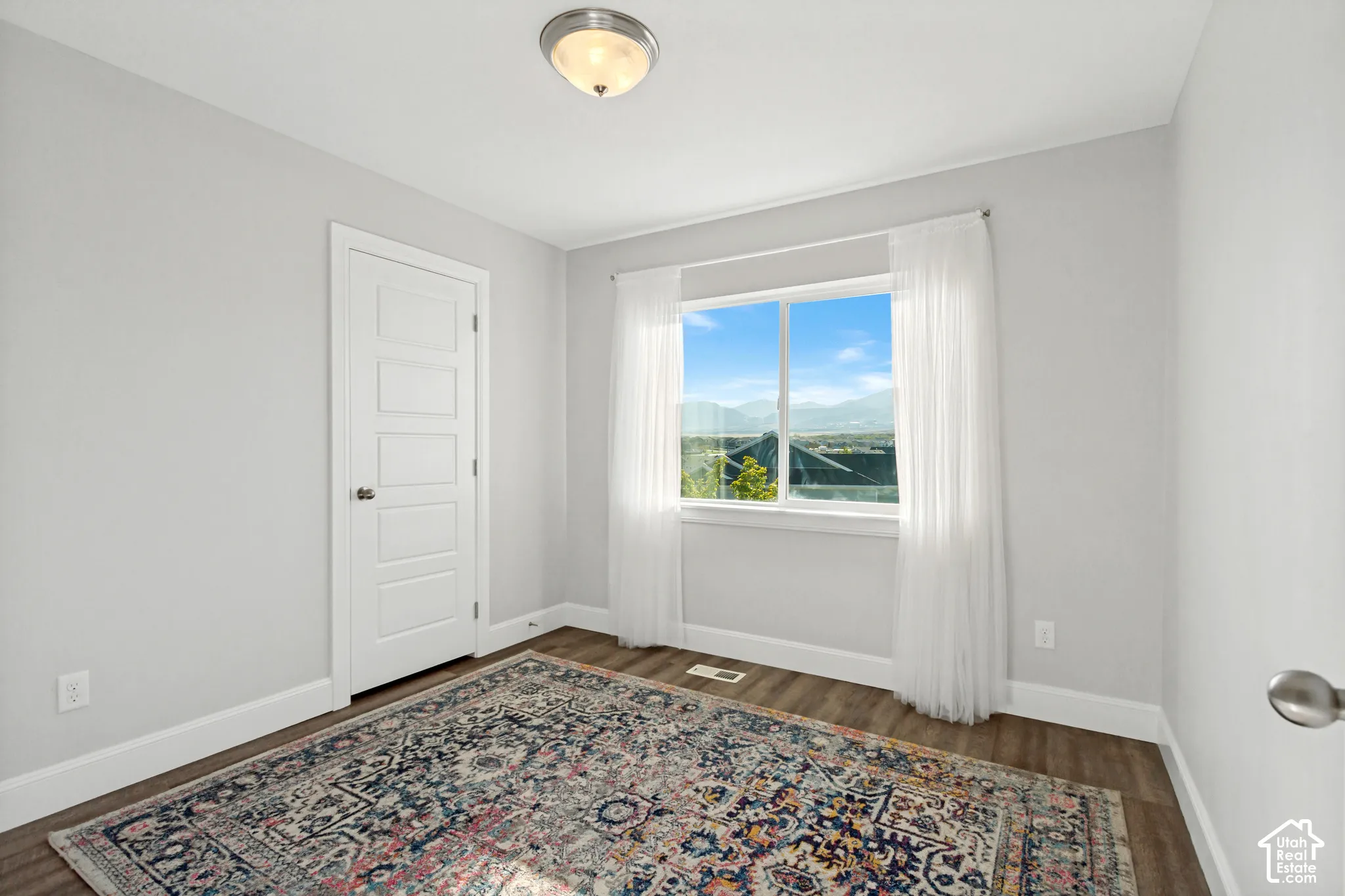 Second bedroom with LVP floorinbg and a large window providing great natural light with mountain views