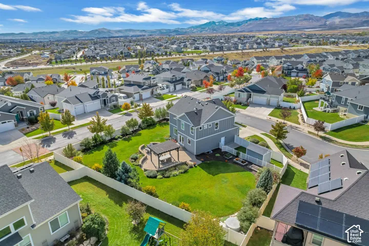 Two-story residence featuring a fenced backyard, hardscaped patio area, wooden pergola, and mountain scenery
