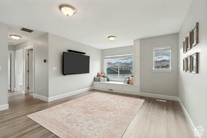 Open and inviting loft area featuring a custom built recessed window seating with built-in storage and excellent natural light