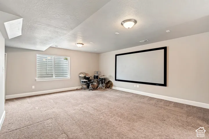 Spacious room with plush carpeting and a large wall-mounted screen
