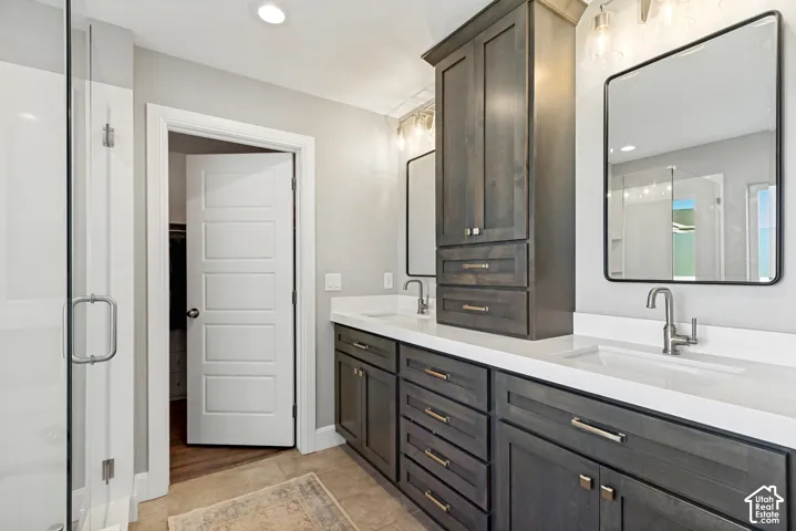 Primary bath with wonderful natural light, dual-sink vanity with custom dark-wood shaker style cabinetry, white quartz countertop, rectangular undermounted sinks, and contemporary recessed medicine cabinets, separate generously sized soaking tub and showe