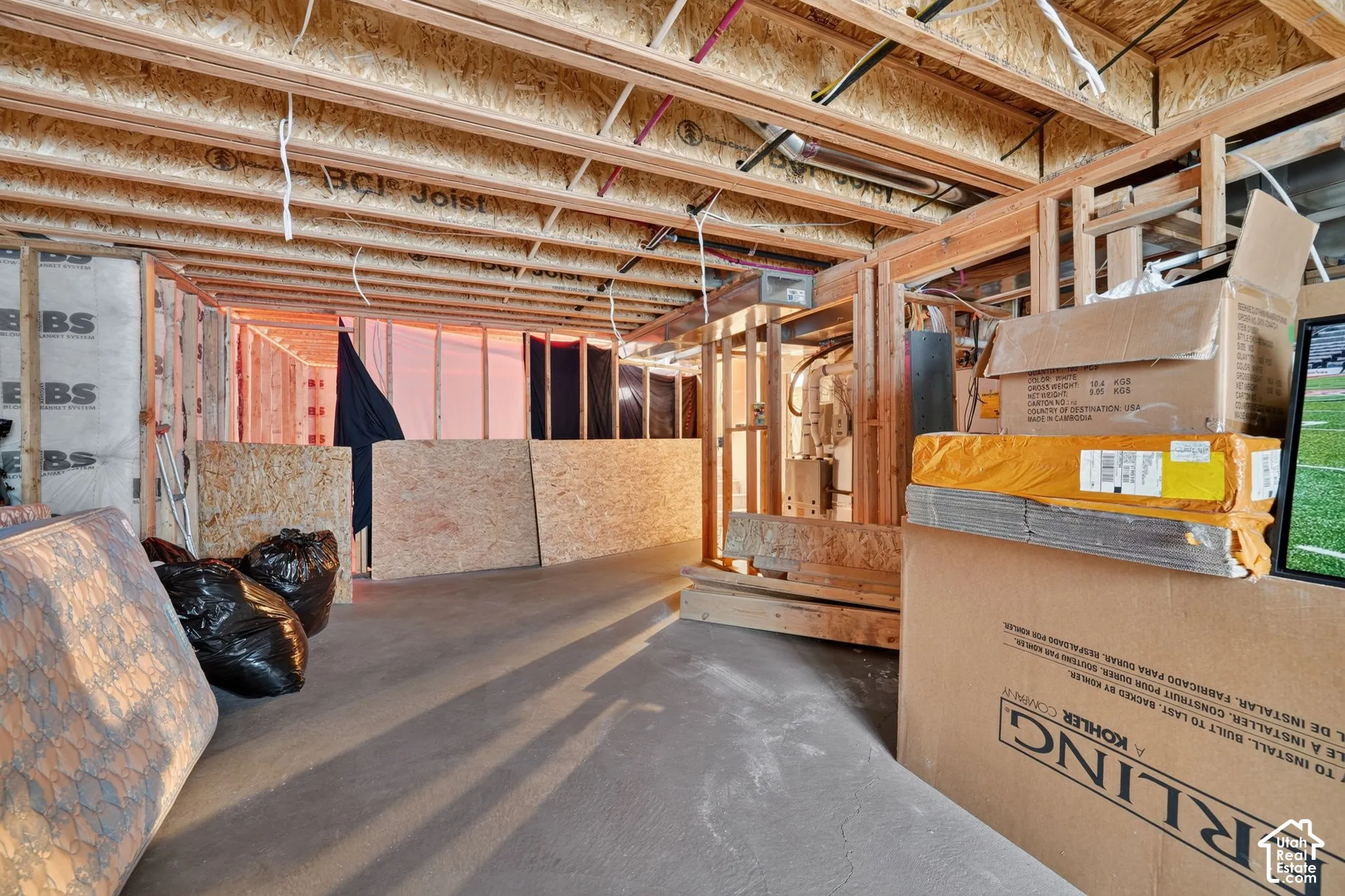Unfinished basement space featuring exposed wooden joists and framing, BCI Joist system, and concrete flooring