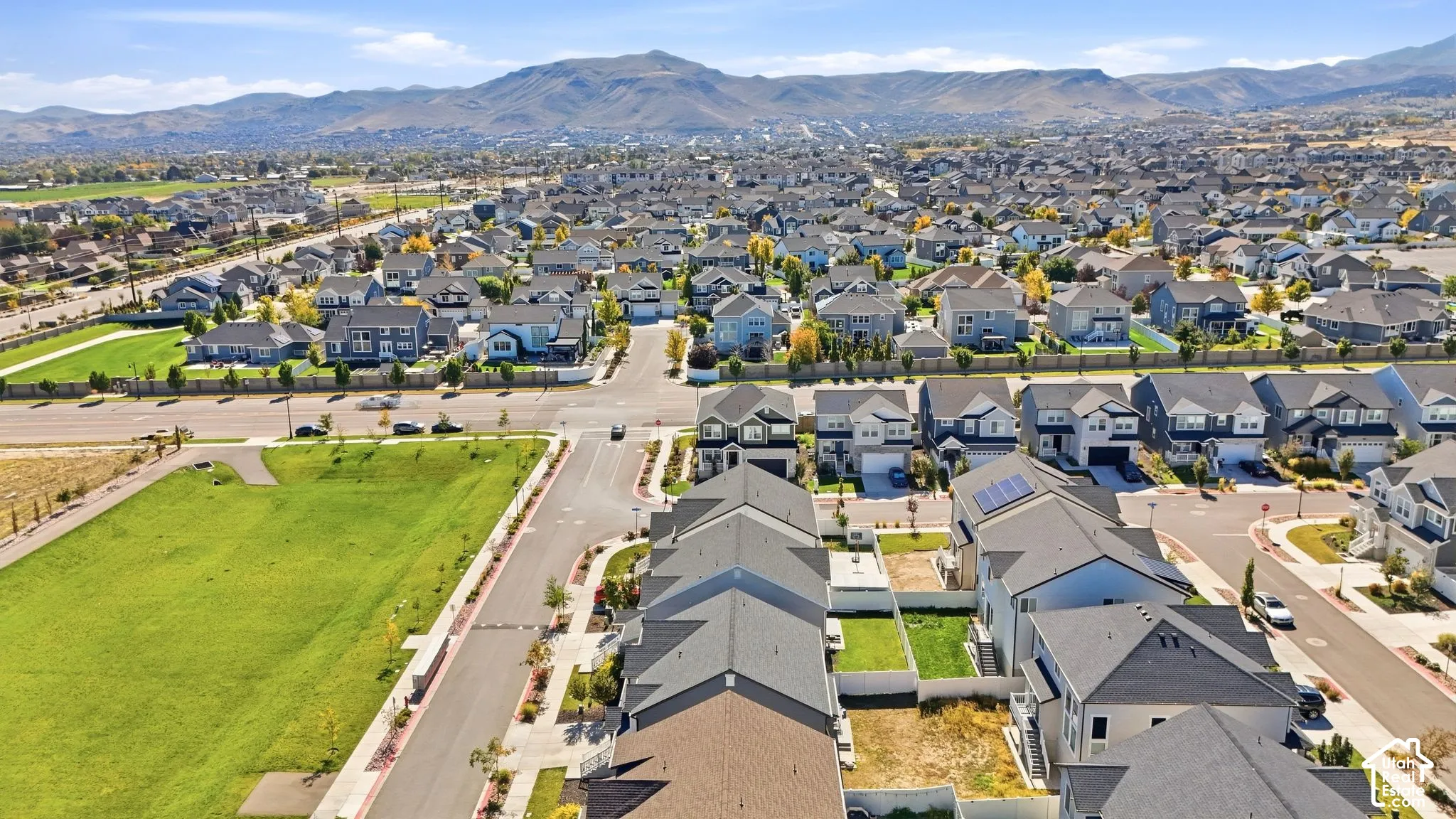 Aerial perspective showcasing a residential community with varied rooflines and surrounding natural landscape