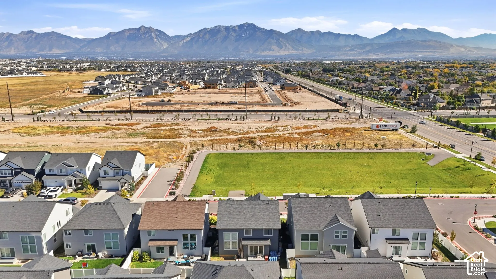 Residential development with mountain backdrop, established green spaces, and paved roads