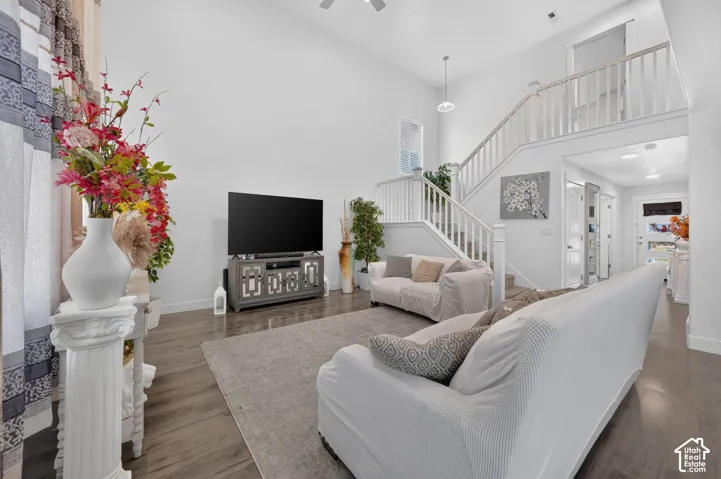 Vaulted ceilings, wood-finish flooring, white painted walls, and a multi-level staircase with white railing