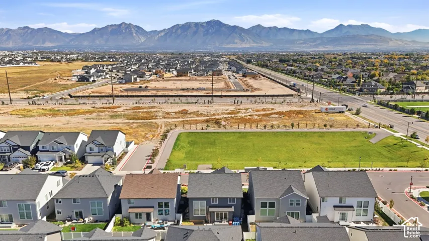 Residential development with mountain backdrop, established green spaces, and paved roads