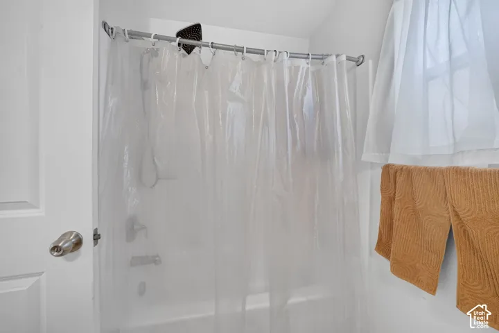 Tub and shower combination with a curved shower rod and ceiling-mounted shower head