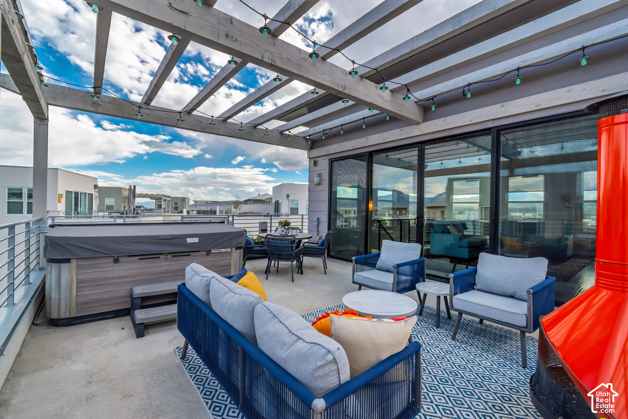 Rooftop patio with a hot tub, wood pergola, multiple sliding glass doors