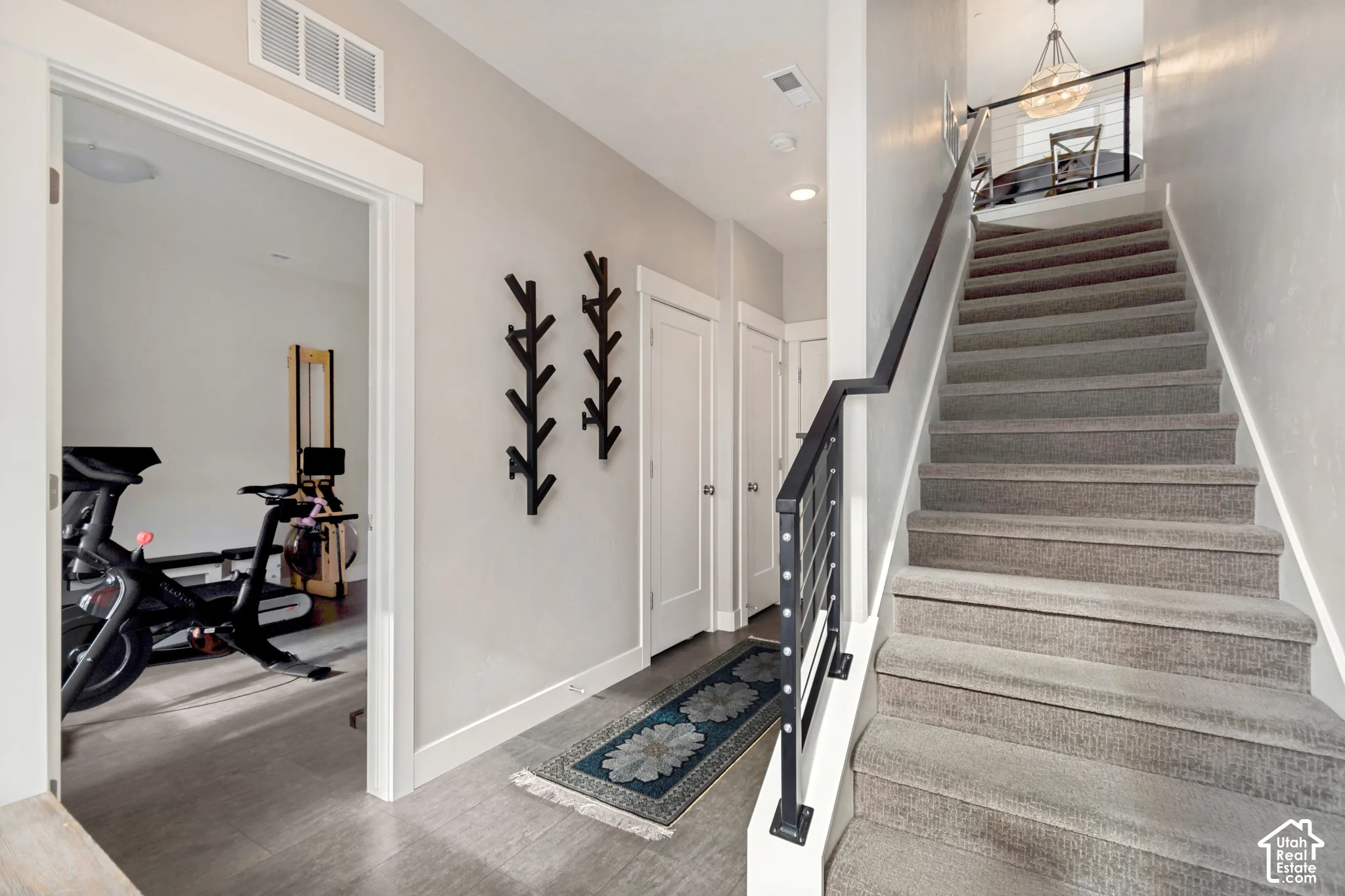 Carpeted staircase with metal and wood-finish railing