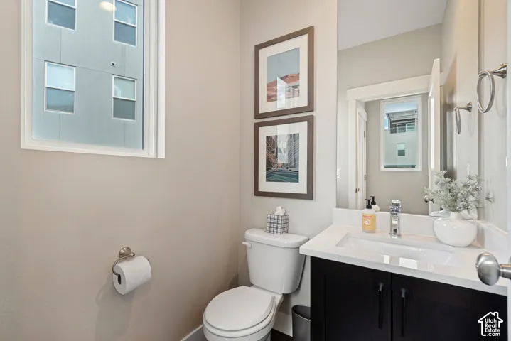 Vanity with integrated sink, dark wood-finish cabinetry, and polished chrome fixtures