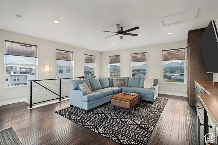 Spacious living area featuring wood-finish flooring, numerous windows, and recessed lighting