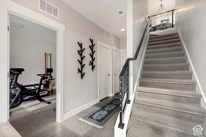 Carpeted staircase with metal and wood-finish railing