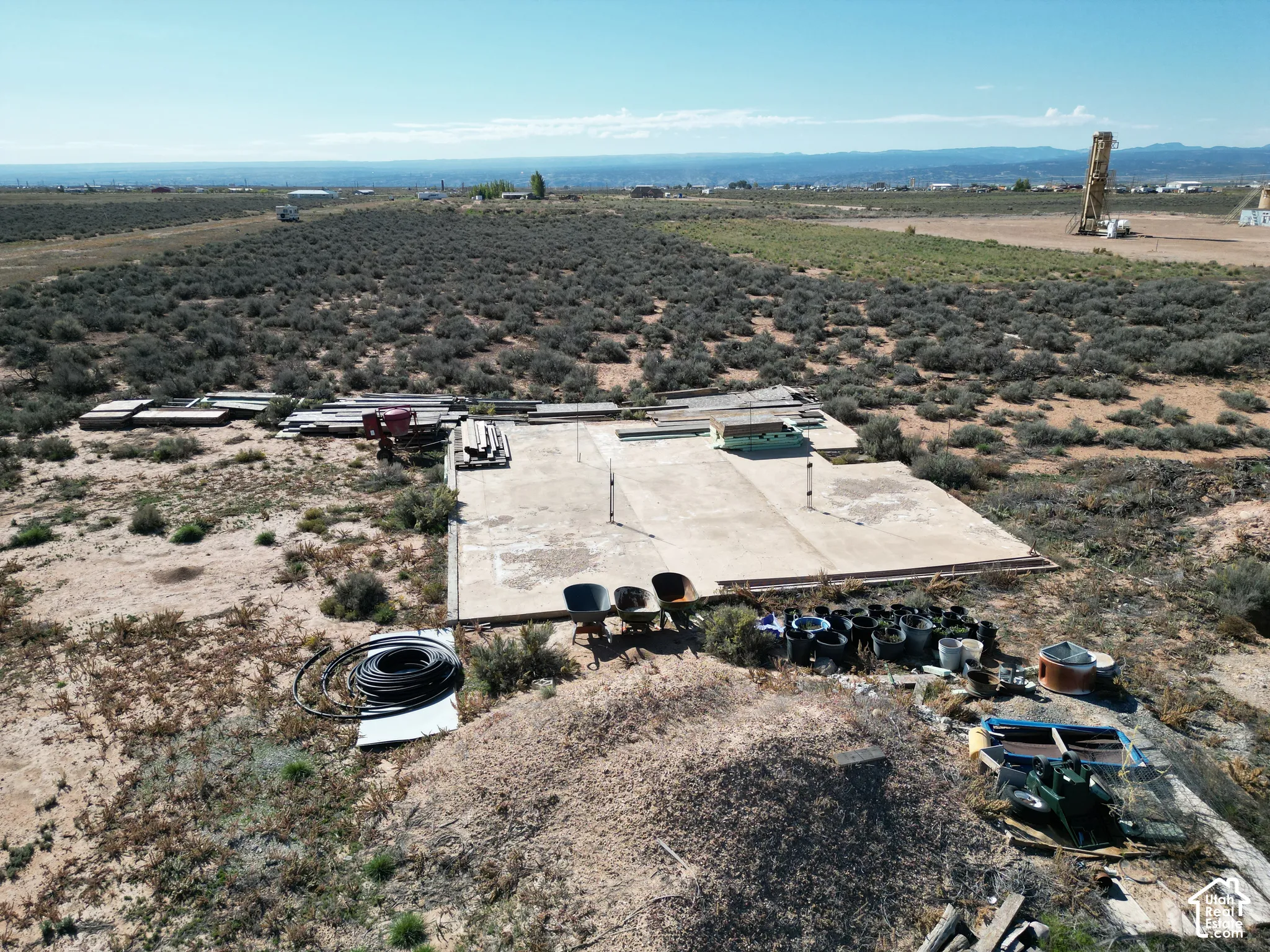 Expansive desert acreage featuring a concrete slab foundation and a prominent mountain backdrop