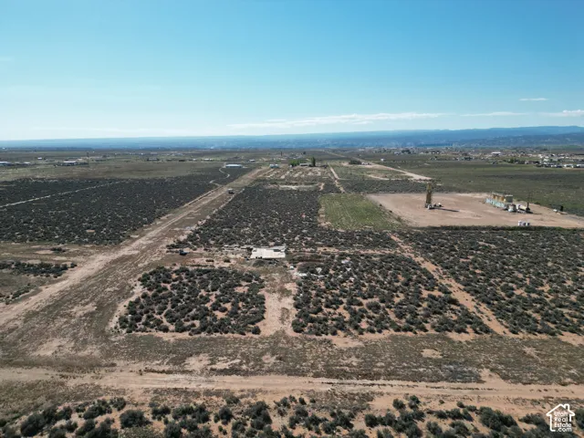 Expansive acreage featuring native desert vegetation, dirt access paths, and mountain horizons