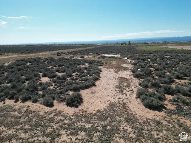 Expansive plot of land featuring native desert vegetation, level topography, and mountain backdrops