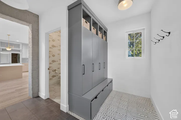 Mudroom with built-in cabinetry with bench seating, black hardware, and open storage
