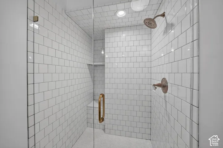 Walk-in shower with subway tile walls, a built-in bench, recessed lighting, and a rainfall showerhead