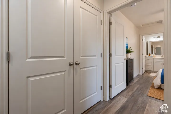Laundry in Halll-Double-panel doors featuring brushed nickel hardware and wood-finish flooring
