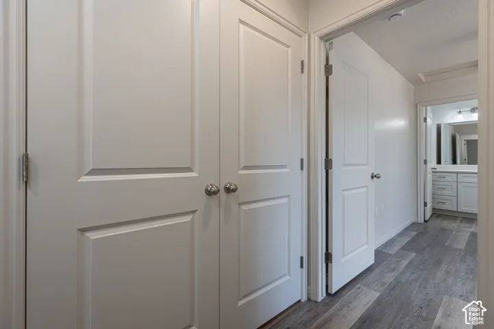 Interior hallway featuring Laundry space wood-finish flooring, two-panel interior doors with satin nickel hardware, and neutral wall paint
