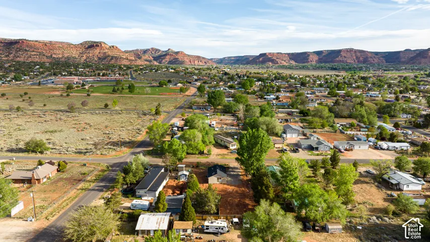 Aerial perspective featuring expansive desert terrain and prominent red rock mountain formations