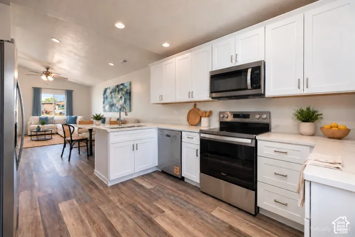 Kitchen featuring white shaker-style cabinetry, wood-finish flooring, recessed lighting, and stainless steel appliances